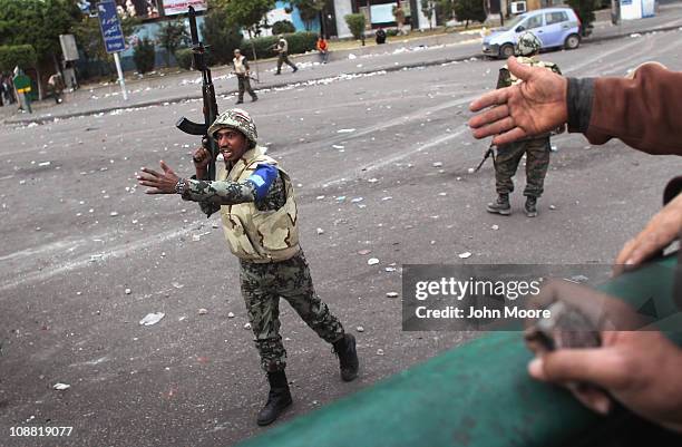 An Egyptian army officer orders anti-government demonstrators to move back on February 3, 2011 in Cairo, Egypt. The Army positioned tanks between the...