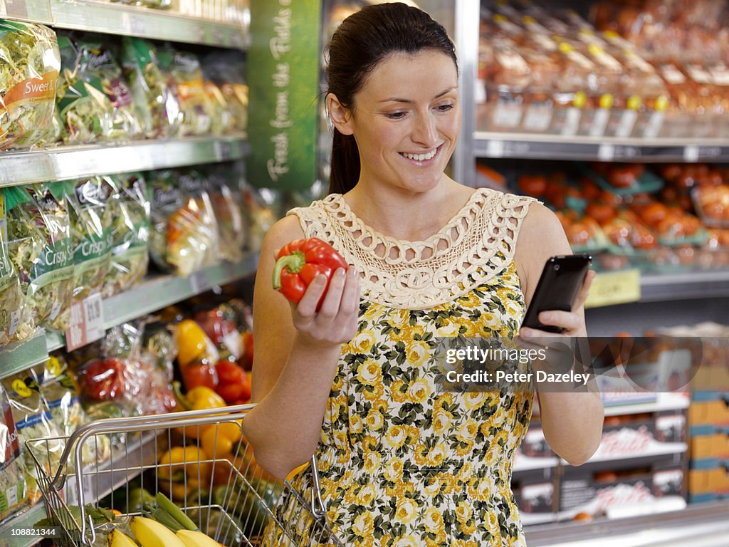 Woman checking shopping list on mobil phone