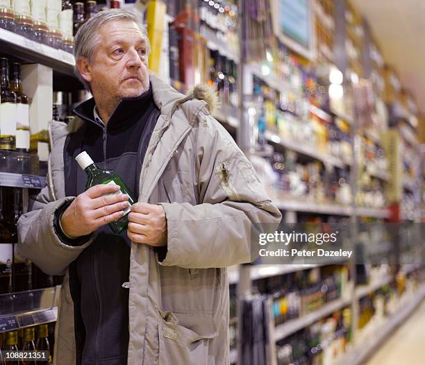 alcoholic stealing gin from supermarket - theft stock pictures, royalty-free photos & images