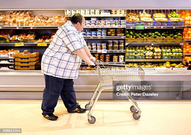 overweight man passing by healthy food - fat guy stock-fotos und bilder