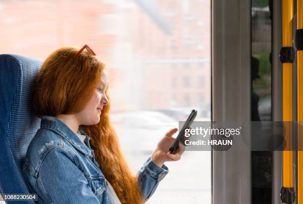 teenage girl browsing on a smart phone in a bus. - bus denmark stock pictures, royalty-free photos & images