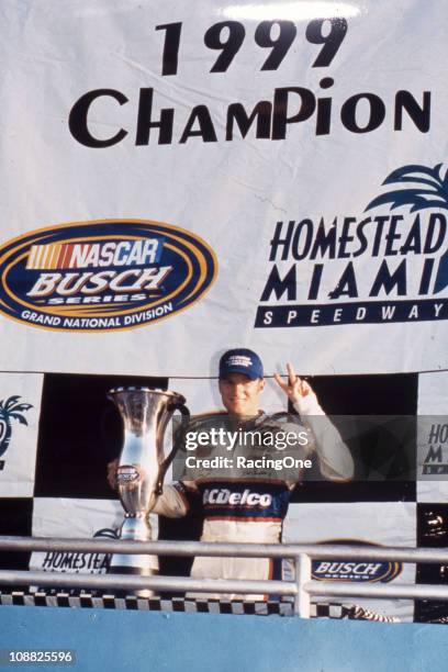 Dale Earnhardt, Jr. Poses with the 1999 championship trophy for the NASCAR Busch Grand National Series. By finishing second in the HotWheels.com 300...