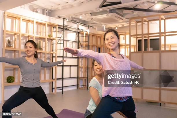 professional yoga instructor supporting woman in health club - 3 gym stock pictures, royalty-free photos & images