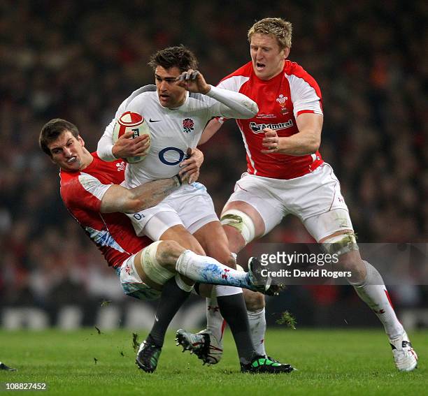 Toby Flood of England is tackled by Sam Warburton and Bradley Davies of Wales during the RBS 6 Nations Championship match between Wales and England...