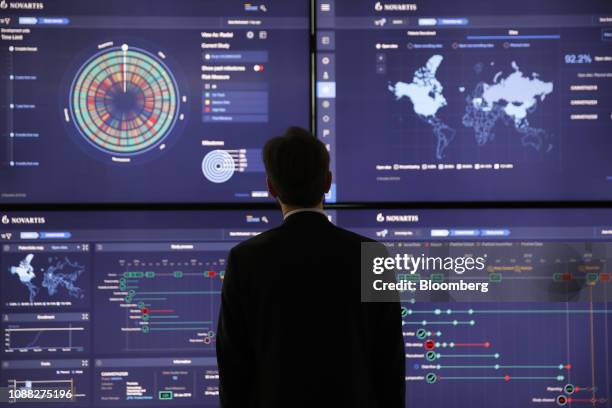 An employee looks at data on screens in the high-tech command center at the Novartis AG campus in Basel, Switzerland, on Wednesday, Jan. 16, 2019....