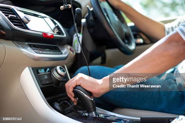man hand on car gear to drive the car - car transmission stock-fotos und bilder