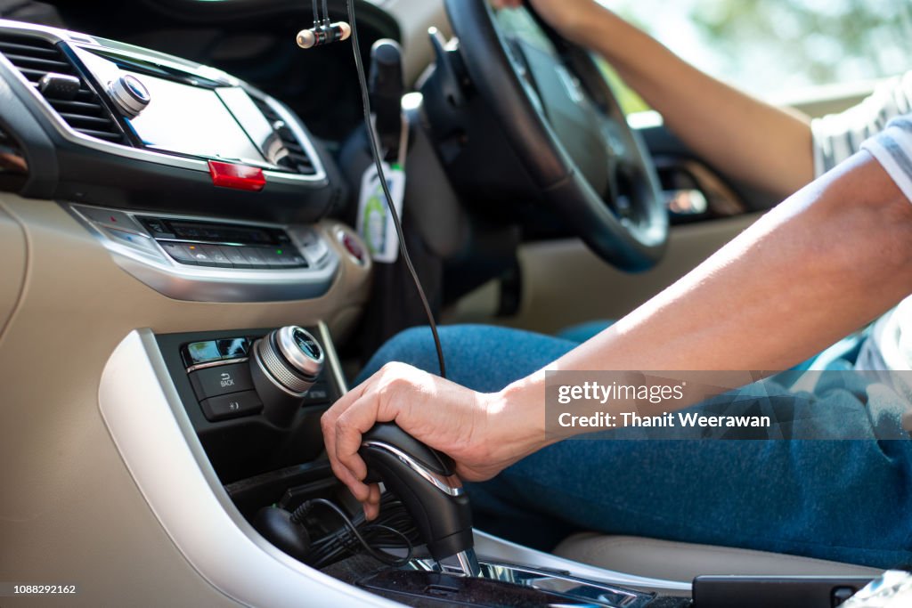 Man hand on car gear to drive the car