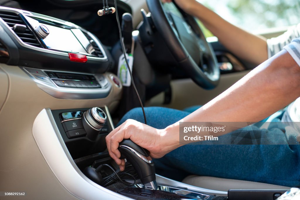 Man hand on car gear to drive the car