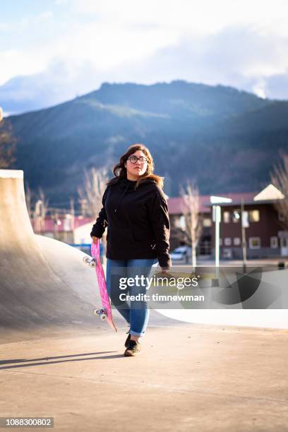 Jovem mulher hispânica adulta skate