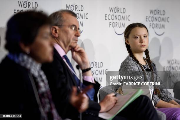 Swedish youth climate activist Greta Thunberg looks on prior to delivering a speech next to moderator Christiana Figueres and Governor of the Bank of...