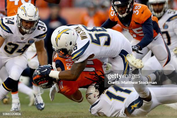 River Cracraft of the Denver Broncos is tackled by Geremy Davis and Kyle Wilson the Los Angeles Chargers returning a punt at Broncos Stadium at Mile...