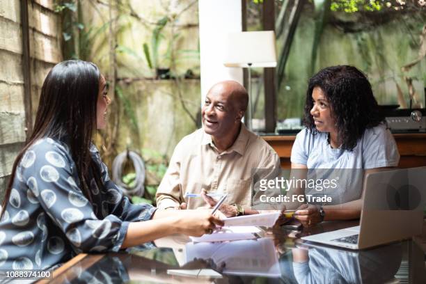 consultant giving advices to the family at home - family meeting stock pictures, royalty-free photos & images