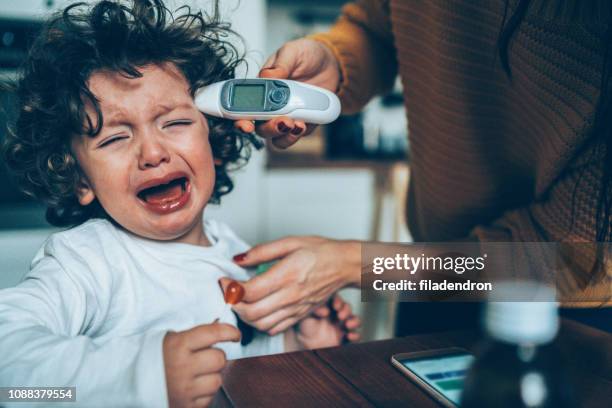 measuring little boy's temperature - baby ear infection stock pictures, royalty-free photos & images