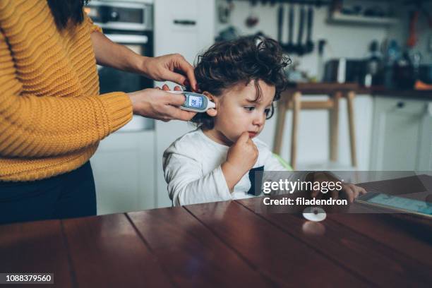 measuring little boy's temperature - digital thermometer stock pictures, royalty-free photos & images