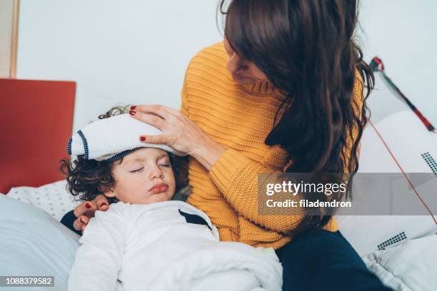 sick little boy in bed - ice pack stock pictures, royalty-free photos & images