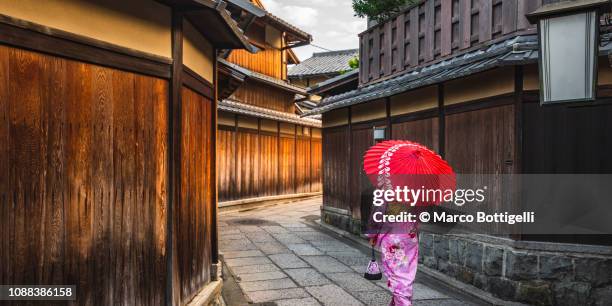 japanese woman walking in the alleys of gion district, kyoto, japan - kyoto stock-fotos und bilder