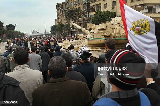 Anti-government demonstrators chant slogans against Egyptian President Hosni Mubarak while gathered around an army tank in Tahrir Square on February...