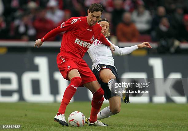 Milivoje Novakovic of Koeln is challenged by Anatoliy Tymoshchuk of Muenchen during the Bundesliga match between 1. FC Koeln and FC Bayern Muenchen...