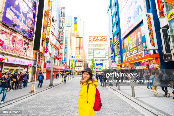 tourist smiling at camera in akihabara electronic town, tokyo, japan - akihabara fotografías e imágenes de stock