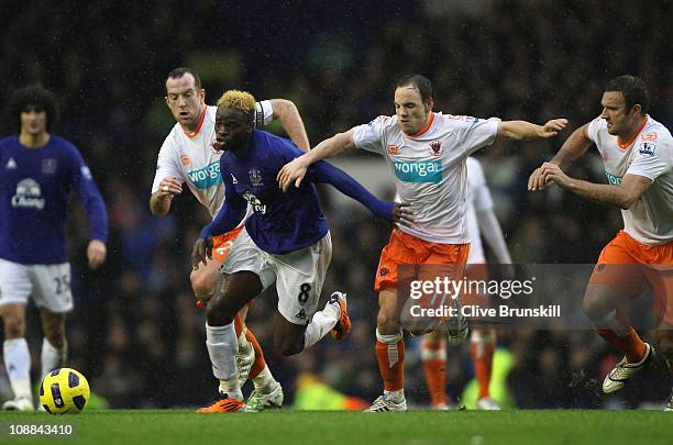 Louis Saha of Everton moves away from Charlie Adam and David Vaughan of Blackpool during the Barclays Premier League match between Everton and...