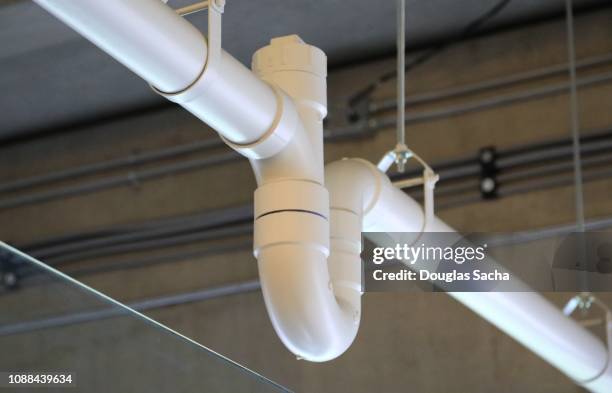 hanging pvc sewer pipe with a trap and clean out fittings - pvc stockfoto's en -beelden