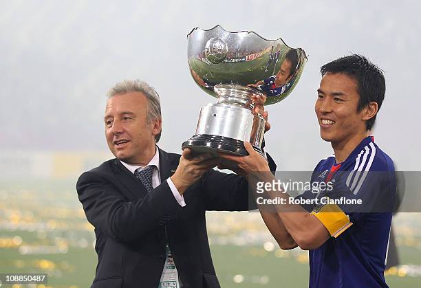 Japanese coach Alberto Zaccheroni and captain Makato Hasebe hold the winners trophy after Japan defeated Australia in extra time 1-0 at the AFC Asian...