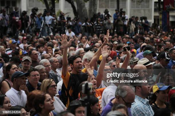 January 2019, Venezuela, Caracas: Numerous demonstrators raise their hands in support of the self-proclaimed interim president Guaido at a rally of...