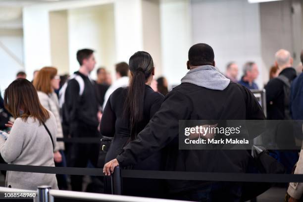 Travelers embrace while waiting in a long security line after Philadelphia Airport TSA and airport workers held a protest rally outside the...