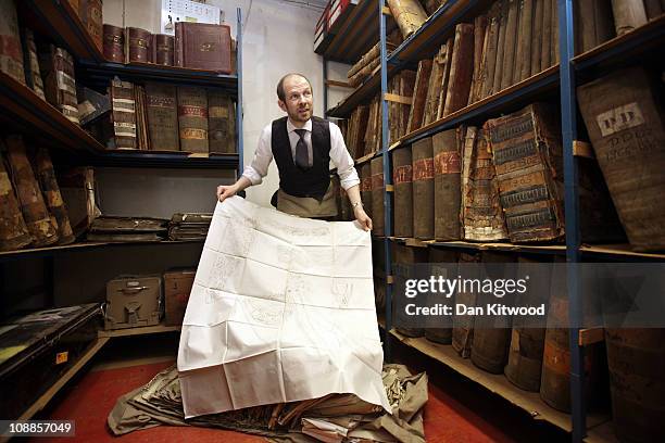 Livery manager Keith Levett displays rubbings of civil and diplomatic uniforms in the archive room at Henry Poole & Co on Savile Row, on February 1,...