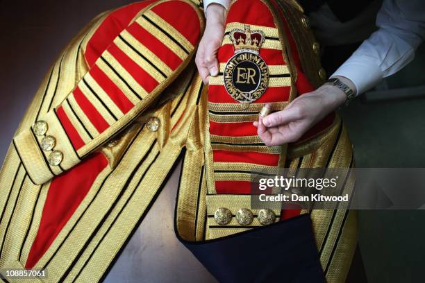 Livery manager Keith Levett sews a State Cypher onto a Footmans full State Livery at Henry Poole & Co on Savile Row, on February 1, 2011 in London,...