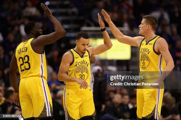 Draymond Green, Stephen Curry and Jonas Jerebko of the Golden State Warriors high-five after scoring against the Phoenix Suns during the second half...