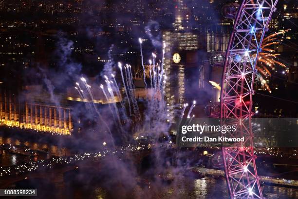 Fireworks explode over The London Eye and Elizabeth Tower near Parliament as thousands of revelers gather along the banks of the River Thames to ring...