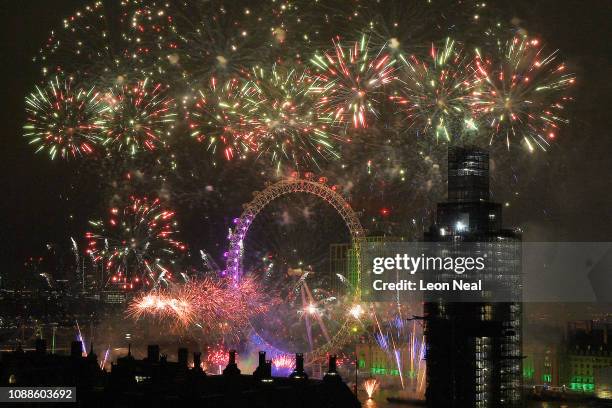 Fireworks explode over Westminster Abbey and Elizabeth Tower near Parliament as thousands of revelers gather along the banks of the River Thames to...