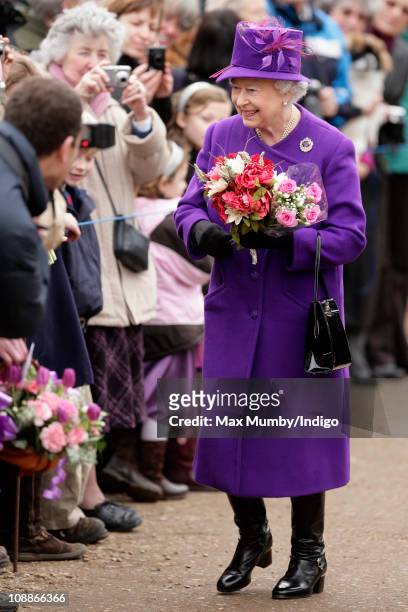 Queen Elizabeth II recieves flowers from members of the public during a walkabout after attending a church service on the 59th anniversary of her...