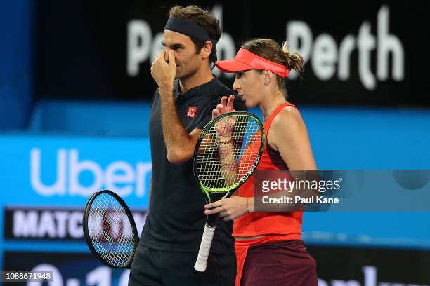 Roger Federer and Belinda Bencic of Switzerland talk tactics in the mixed doubles match against Serena Williams and Frances Tiafoe of the United...