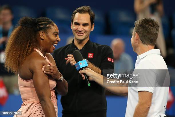 Serena Williams of the United States and Roger Federer of Switzerland are interviewed on court following their mixed doubles match during day four of...