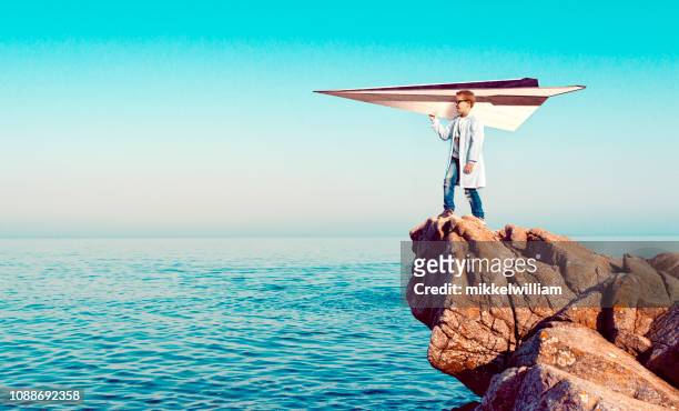 niño prodigio ha creado un avión de papel y está listo para dejar que se despegue - big dreams fotografías e imágenes de stock