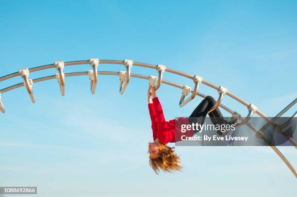 girl playing on a climbing frame - kletterstange stock-fotos und bilder