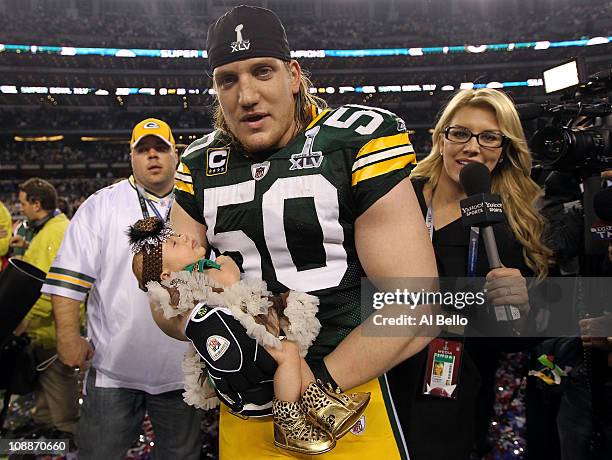 Hawk of the Green Bay Packers celebrates with his baby after winning Super Bowl XLV 31-25 against the Pittsburgh Steelers at Cowboys Stadium on...