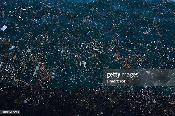 garbage floating on the surface of sea - watervervuiling stockfoto's en -beelden