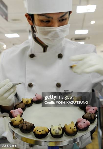 Japan's sweet shop Goncharoff chocolatier puts the finishing touches to animal-shaped chocolates at Takashimaya department store's Valentine's Day...