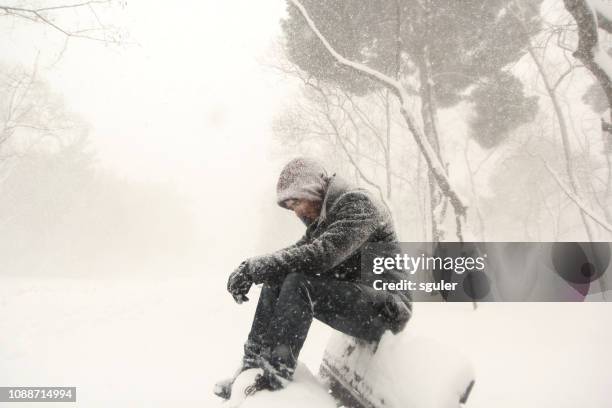 man sitting on bench - homeless person in snow stock pictures, royalty-free photos & images