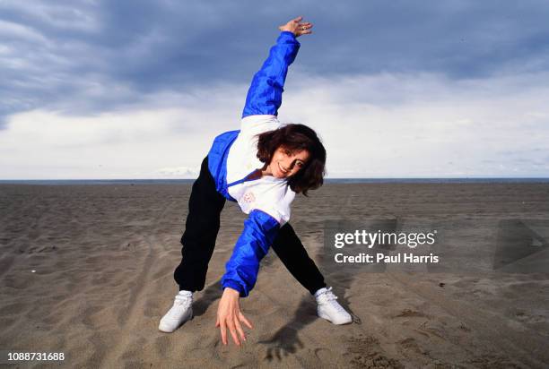 Nadia Comaneci an Olympic athlete January 1, 1991 stretches on Santa Monica Beach, Los Angeles, California