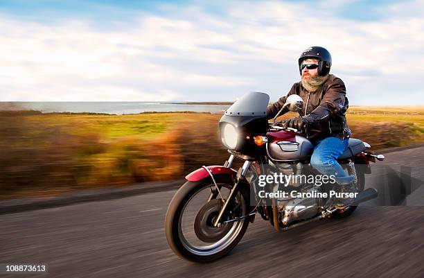 bearded biker riding motorcycle next to ocean - motorbike ride stock pictures, royalty-free photos & images