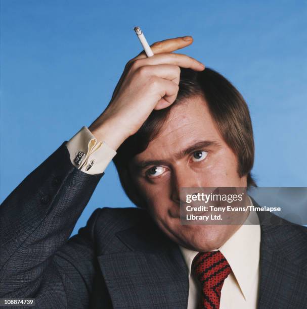 English impressionist and comedian, Mike Yarwood with a cigarette, 1975.