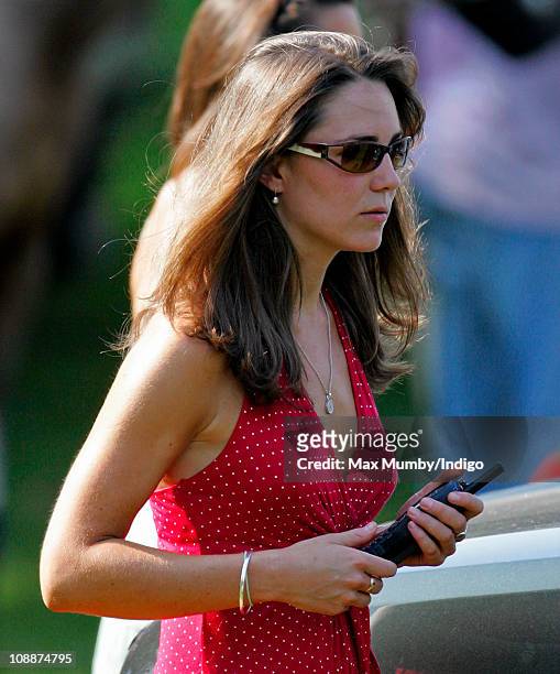 Kate Middleton carries a Police radio as she watches Prince William compete in the Chakravarty Cup charity polo match at Ham Polo Club on June 17,...