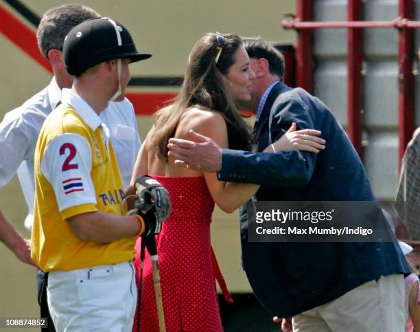 Prince William looks on as Kate Middleton kisses his Private Secretary Jamie Lowther-Pinkerton as they attend the Chakravarty Cup charity polo match...