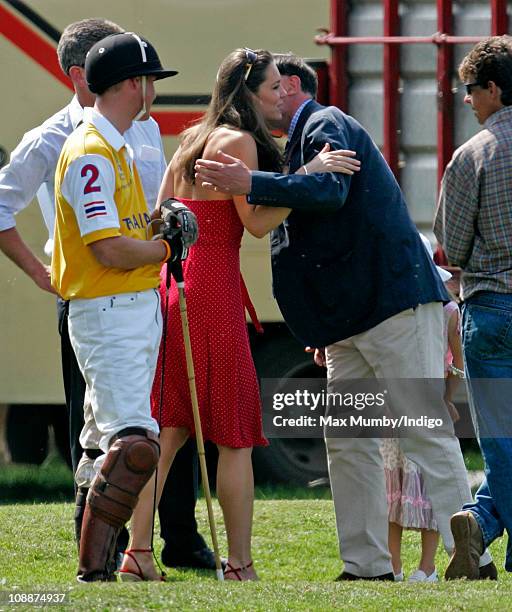 Prince William looks on as Kate Middleton kisses his Private Secretary Jamie Lowther-Pinkerton as they attend the Chakravarty Cup charity polo match...