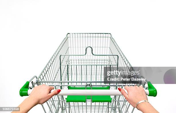 supermarket trolley with woman's hands on white - first person perspective stock-fotos und bilder