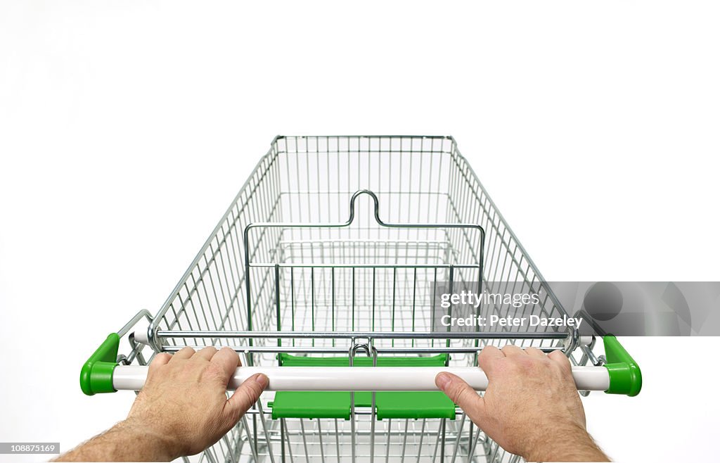 Supermarket trolley with man's hands on white